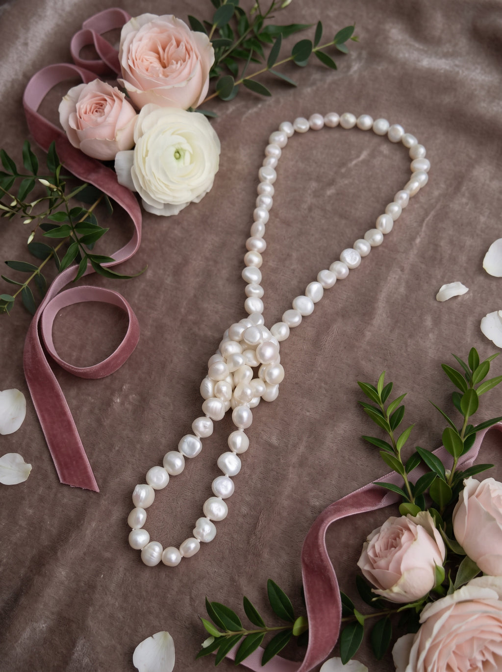 Blue Dragonfly Creations long white baroque freshwater pearl necklace with hand-knotted detail on velvet background