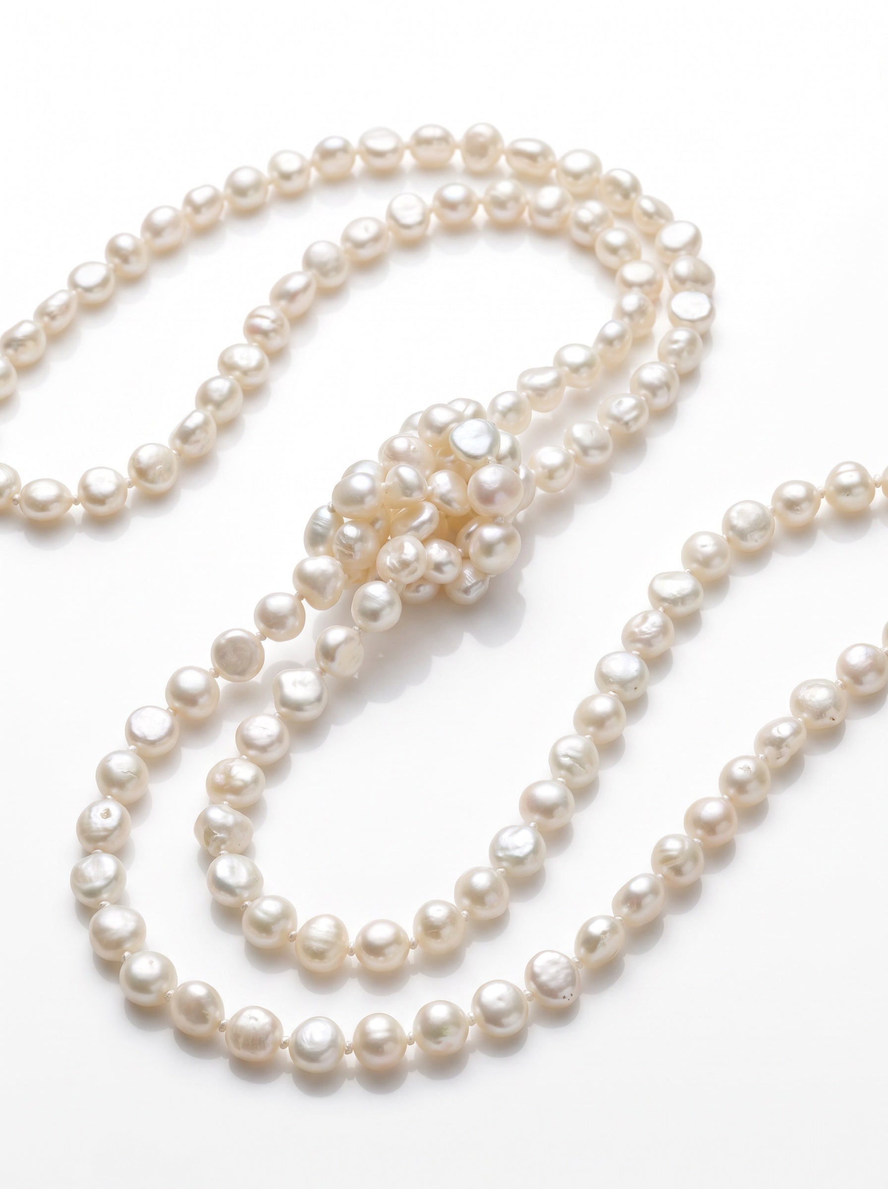 Blue Dragonfly Creations long white baroque freshwater pearl necklace with hand-knotted detailing on white background