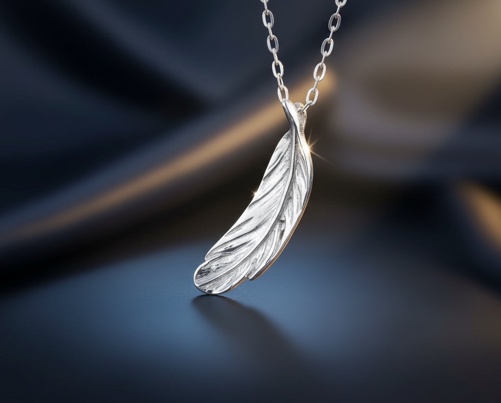 Blue Dragonfly Creations fine silver feather pendant necklace with detailed texture on a dark satin background