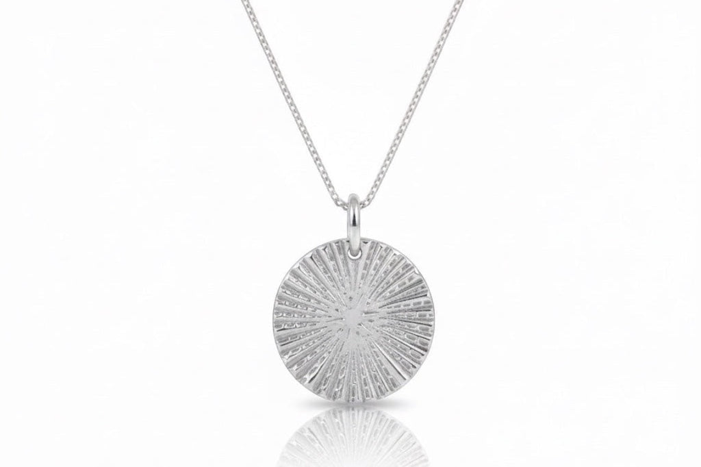 Blue Dragonfly Creations fine silver round pendant necklace with textured sunburst lines on a sterling silver chain.