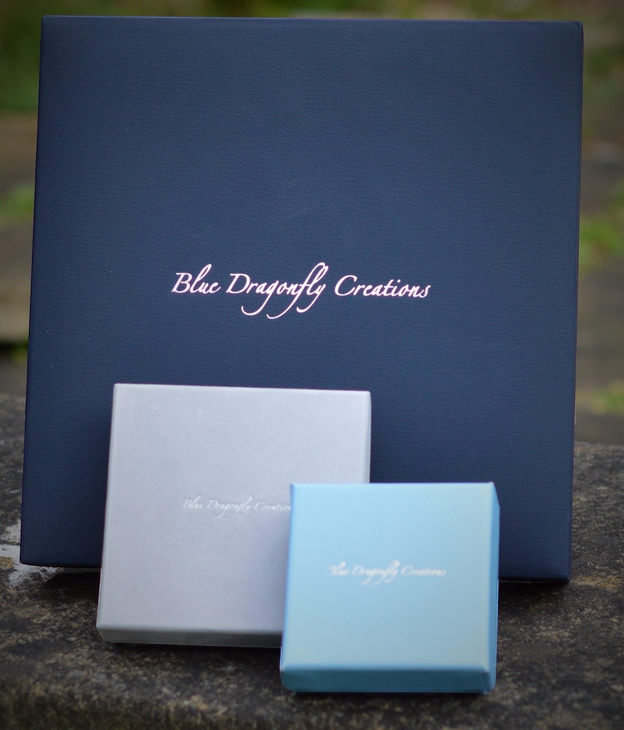 Blue Dragonfly Creations branded jewellery gift boxes in navy, silver, and light blue for a fine silver necklace.
