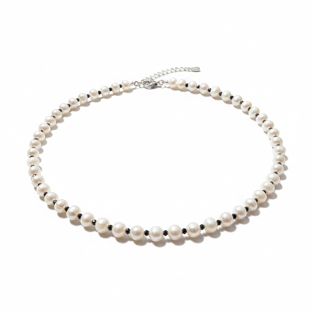 Blue Dragonfly Creations freshwater pearl necklace with faceted black beads and a sterling silver clasp on white.