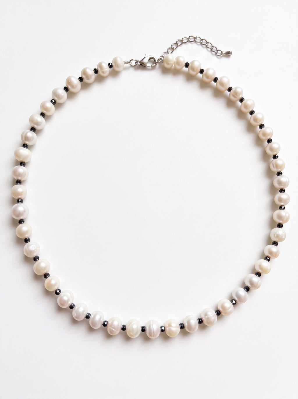 Blue Dragonfly Creations freshwater pearl necklace with faceted black beads and sterling silver clasp on white background