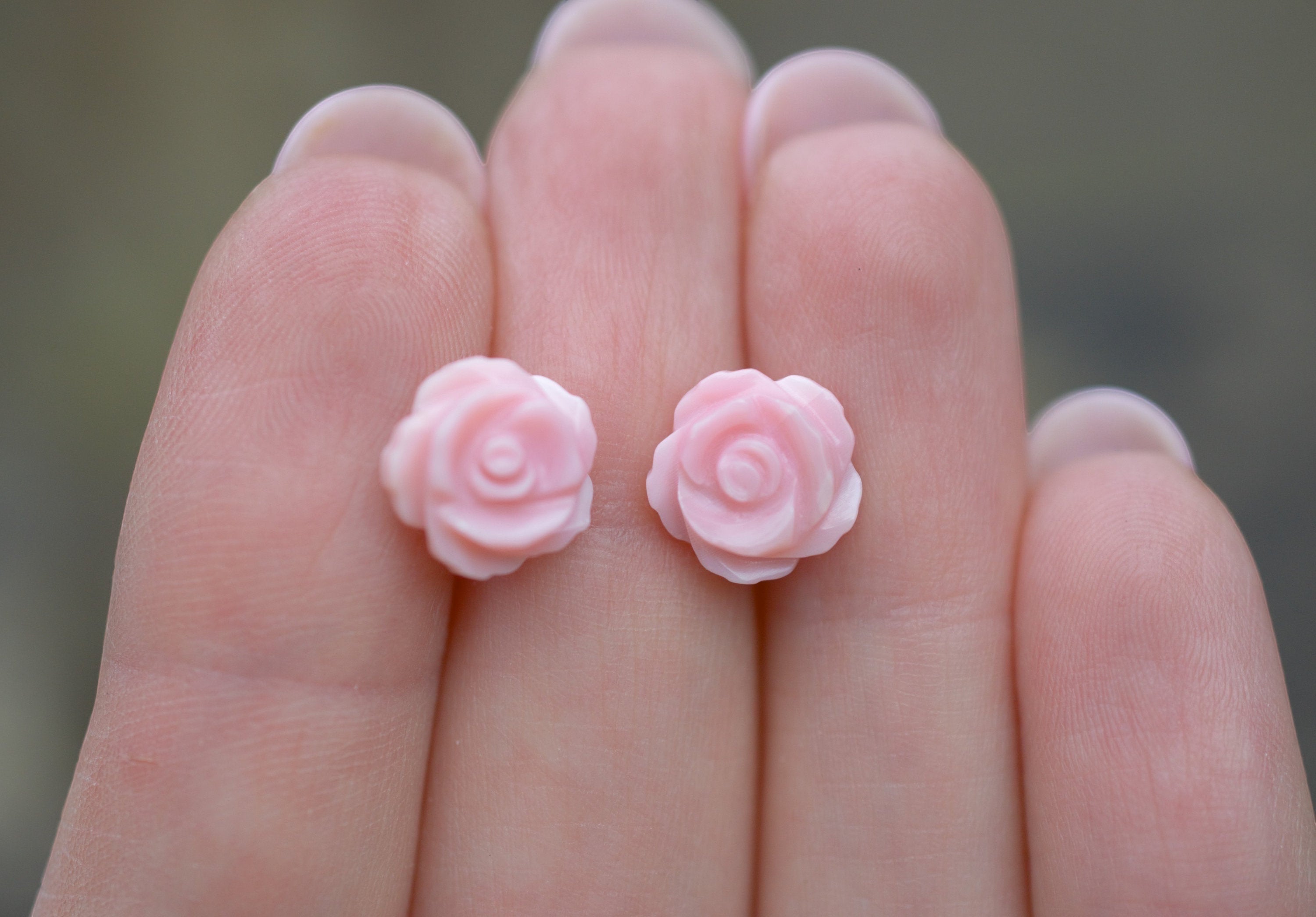 Blue Dragonfly Creations pink carved shell rose flower stud earrings on sterling silver held in fingers