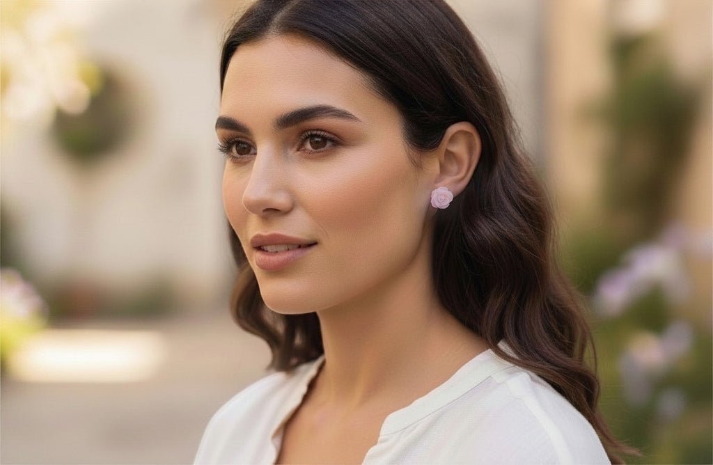 Blue Dragonfly Creations pink carved shell rose flower stud earrings worn by a woman in a soft outdoor setting