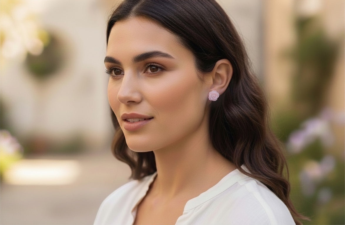 Blue Dragonfly Creations pink carved shell rose flower stud earrings worn by a woman in a soft outdoor setting