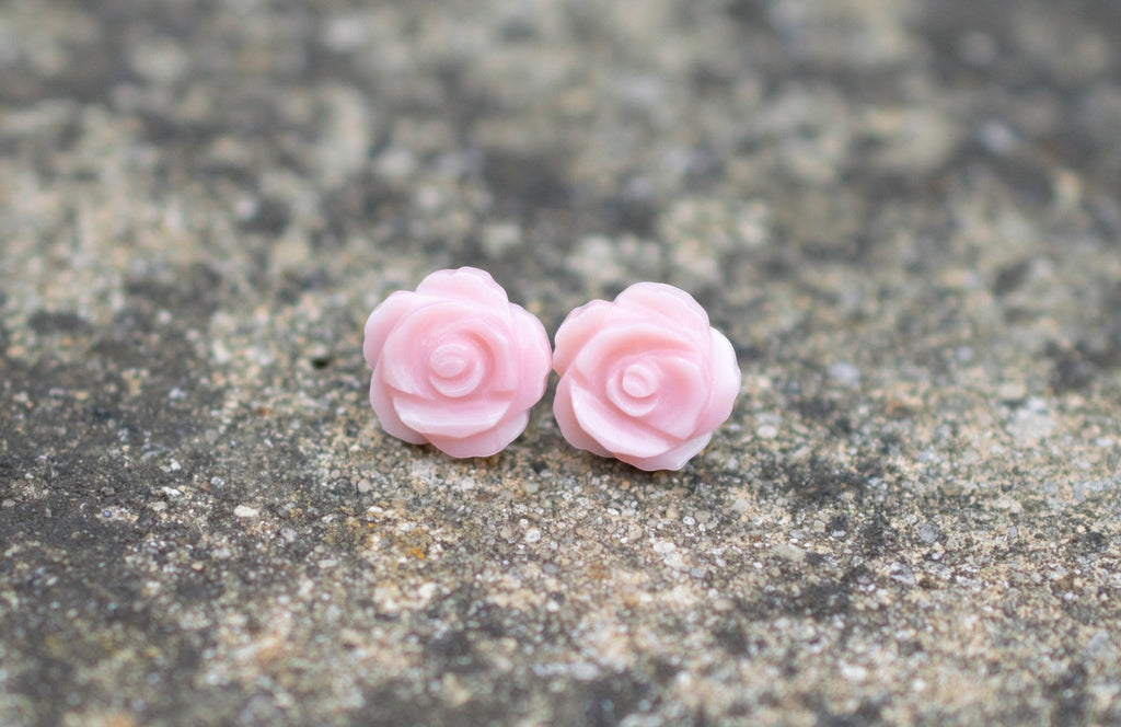 Blue Dragonfly Creations pink carved shell rose flower stud earrings with sterling silver backs on a textured surface