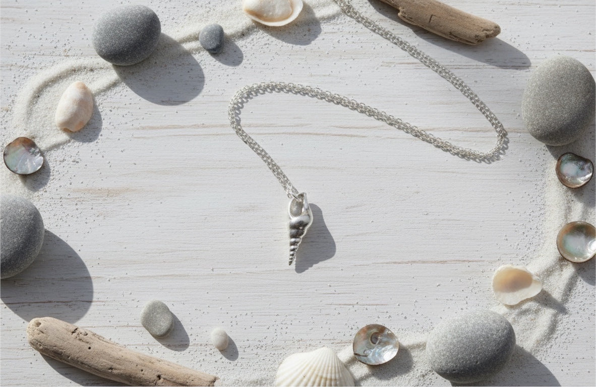Blue Dragonfly Creations fine 999 silver seashell pendant necklace on a sterling silver chain against a sandy background